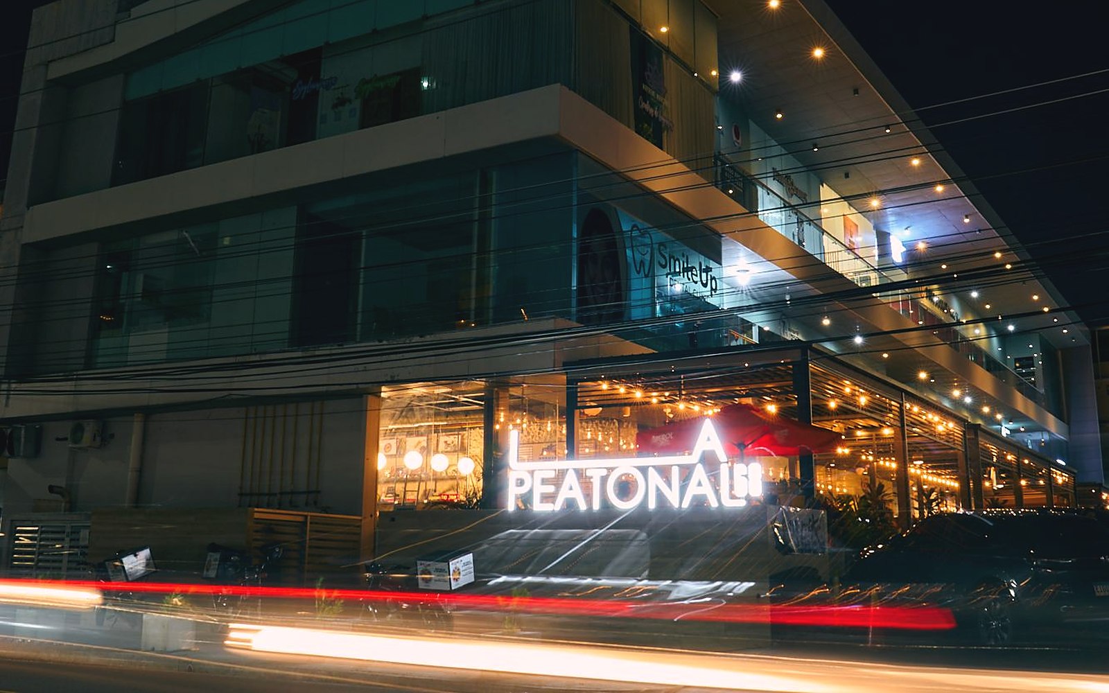 Plaza La Peatonal 68 de noche, con el rótulo encendido sobre Calle 68 Este