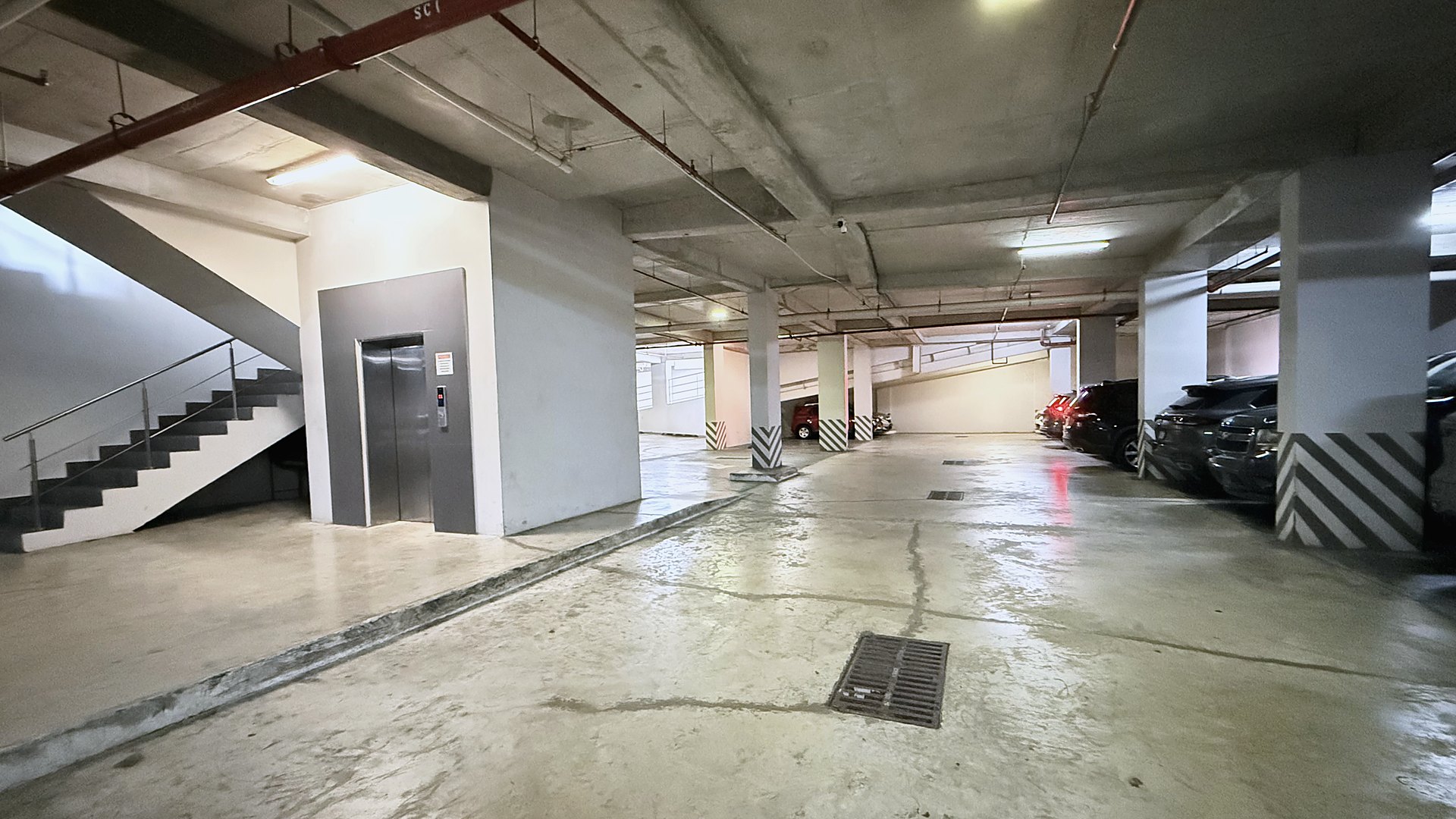 Sótano bajo techo de Plaza La Peatonal 68 con el núcleo de ascensor y escaleras